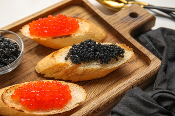 Tasty bruschettas with red and black caviar on white background