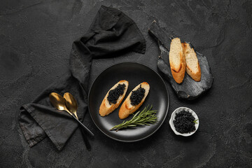 Tasty bruschettas with black caviar on dark background