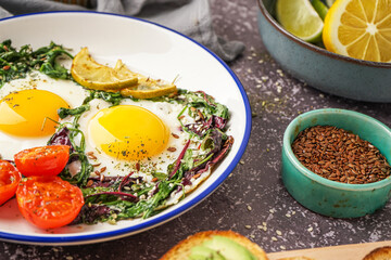 Plate with tasty fried eggs and salad on grey background