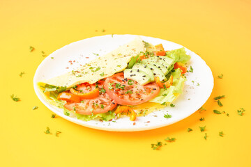 Tasty omelet with vegetables on yellow background
