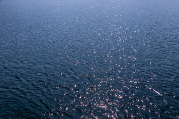 太陽の光を反射しながら穏やかに揺れる青い水面