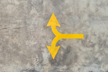 Aerial top down view of the yellow color two way arrow painting on the cement floor