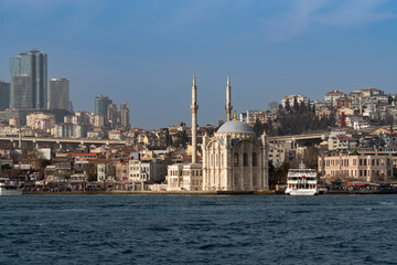 Fototapeta na wymiar Ortakoy Mosque (Buyuk Medjidie Kamii) in Besiktas district on the embankment of the Ortakoy Pier Square from the waters of the Bosphorus, Istanbul, Turkey