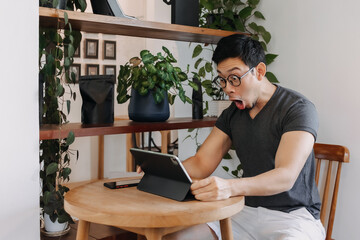 Wow and surprise face of freelance asian man working in the cafe.