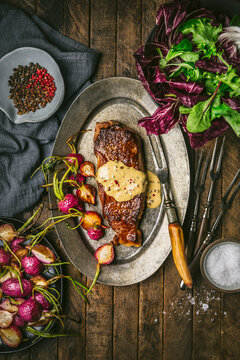 Steak au poivre on platter with roasted radishes