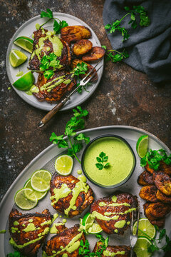 Peruvian Chicken thighs on platter with plantains and sauce 2