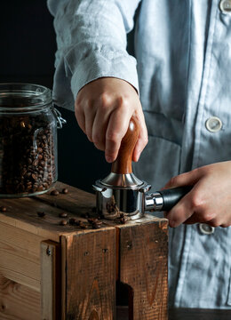 Barista hold portafilter and coffee tamper make coffee in coffee shop or cafe, dark backgrounds