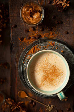 A sweet latte coffee drink made with cookie butter and garnished with cookie crumbs. Presented in a ceramic mug.