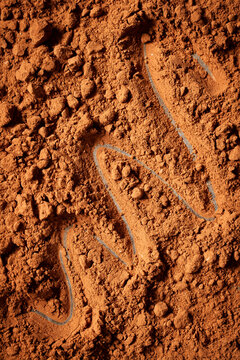 Coco powder on a flat surface with a zig-zig train sketched into it.