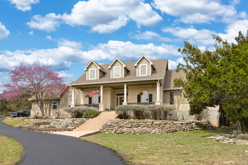 traditional  home with a green lawn and cherry blossoms