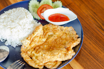 Minced pork omelet on wooden table, Thai Breakfast, side view