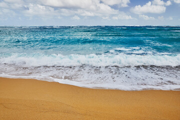 Ocean waves breaking onto a sand beach