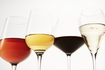 Pink, white, red, sparkling alcoholic drinks in wine glasses.
