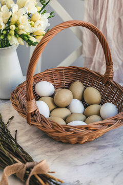 Green eggs in a wicker basket on a white marble table