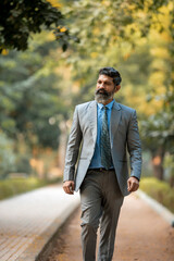 Fototapeta premium Confident Indian corporate man giving expression at park.