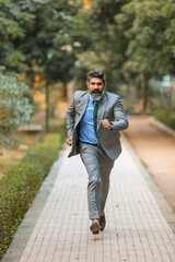 Obraz premium Indian corporate man running at park.