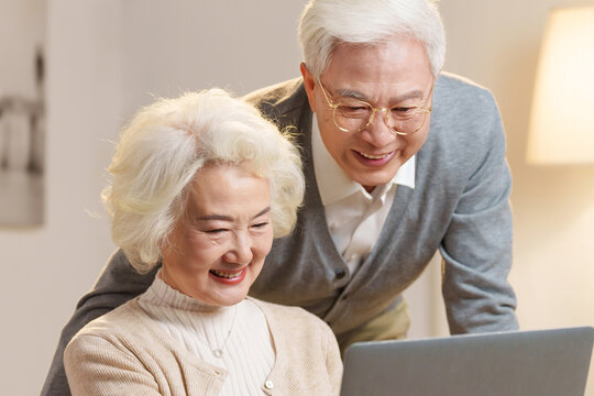 Elderly couple using laptops