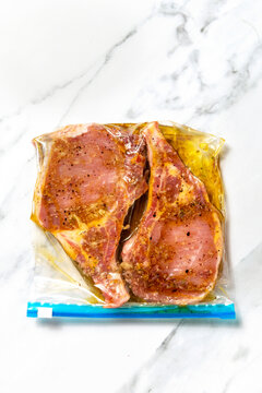 Raw pork chops marinating in a plastic bag