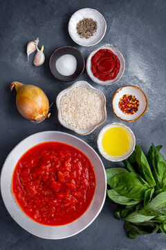 Tomato sice soup ingredients photographed on a grey background.