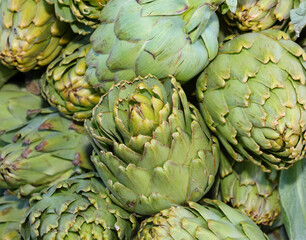 Fototapeta premium background of green large ripe artichokes for sale at market