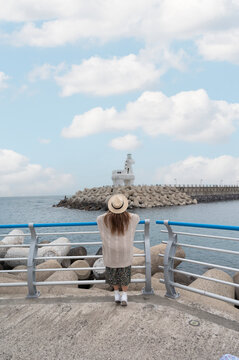 Lady tourist travel at Lighthouse of Iho tewoo Beach, Jeju Island, South Korea