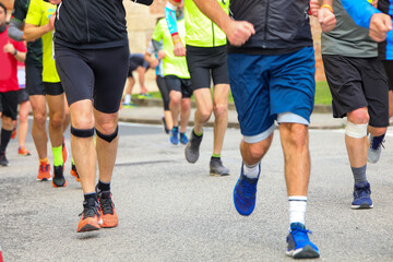 athletes with sports clothes run during the running race in the paved road in the city
