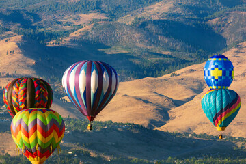 Colorful hot air balloons flying over the mountains