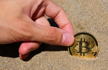 hand holding a coin with letter B symbolizing cryptocurrency investment
