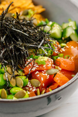 Portion of gourmet salmon poke bowl with vegetables