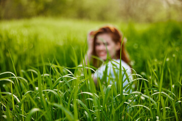 photograph of a woman sitting in the grass focusing on grass leaves