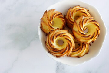 Cottage cheese muffins cupcakes in a plate on the marble  table top view. Copy space.Delicious homemade curd muffins. Sweet baked pastry.