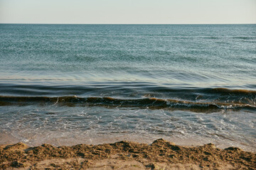 seascape with rolling waves on a calm, sunny day at sunset