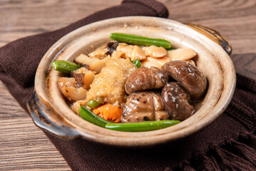 braised assorted dried seafood sea cucumber mushroom bean curd skin and broccoli mixed vegetables in sauce casserole on wood table asian chinese halal food banquet menu for restaurant
