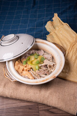 braised boiled pork meat pig stomach bean curd skin sour vegetables herbal and white pepper healthy hot soup in casserole on wood table asian chinese halal food banquet menu for restaurant