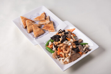 stir fried white shimeji mushroom with scallop black fungus cashew nut deep fried yam bean curd and mixed colourful vegetables on wood table asian Chinese vegan halal food banquet menu for restaurant