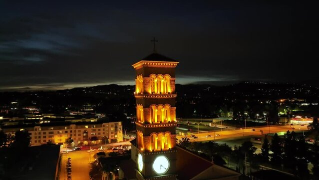 Cinematic night view of St. Andrews Church in Pasadena, aerial pullback over city