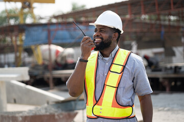 Portrait African American engineer man working with walkie talkie at precast cement factory background	