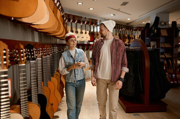 Woman consultant talking to man buyer at musical instrument shop