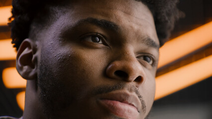 Young African American man straight and serious face with confident deep look. Focused worker looks...