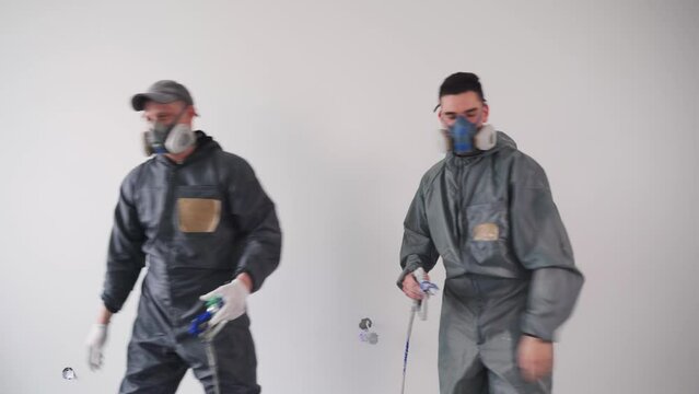 High five at the construction site. Colleagues builders painters talk, give five and disperse.