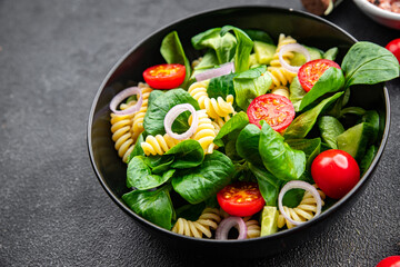 fresh salad pasta, tomato, cucumber, green leaf mix, Fusilli meal food snack on the table copy space food background rustic top view