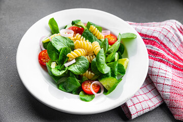 fresh salad pasta, tomato, cucumber, green leaf mix, Fusilli meal food snack on the table copy space food background rustic top view