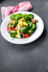 fresh salad pasta, tomato, cucumber, green leaf mix, Fusilli meal food snack on the table copy space food background rustic top view