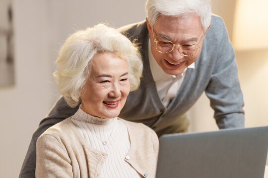 Elderly couple using laptops