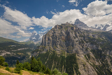 Paragliding in the Swiss Alps as captured from the town of Murren, nestled below the Schilthorn mountain peak