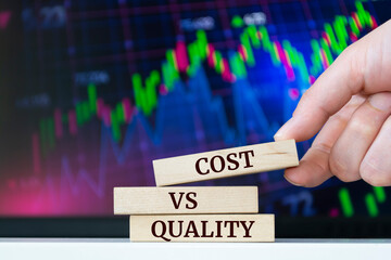 Wooden blocks with words 'COST VS QUALITY'. Business concept