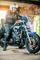 Fototapeta na wymiar Man sitting on a motorcycle in a garage.