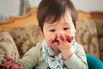 young child enjoying eating marmalade / jam / jelly