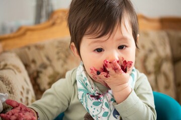 young child enjoying eating marmalade / jam / jelly