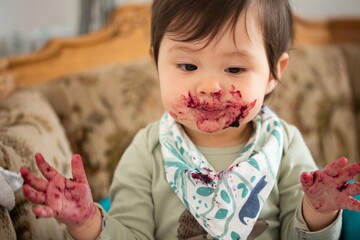 young child enjoying eating marmalade / jam / jelly